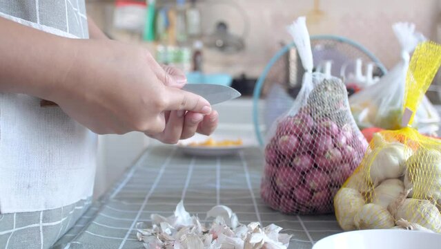 Woman peeling the garlics preparing for cooking the food
