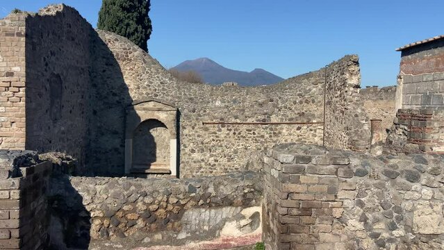 Old house in roman town of Pompeii with Vesuvius behind. Panning