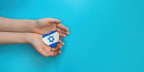 banner of a child's hands holding an Israeli flag in the shape of a heart. Concept of peace at...