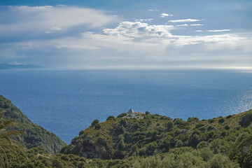 Fototapeta na wymiar Corsica, seascape of the cap Corse, a chapel in the mountain, turquoise sea on sunny day 