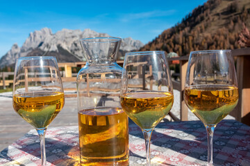 White wine carafe and glasses with scenic view of majestic ridges of Carnic Alps, Friuli Venezia...
