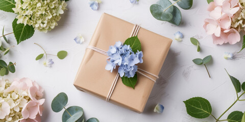Gift box and  fresh flowers on light background. Congratulating card