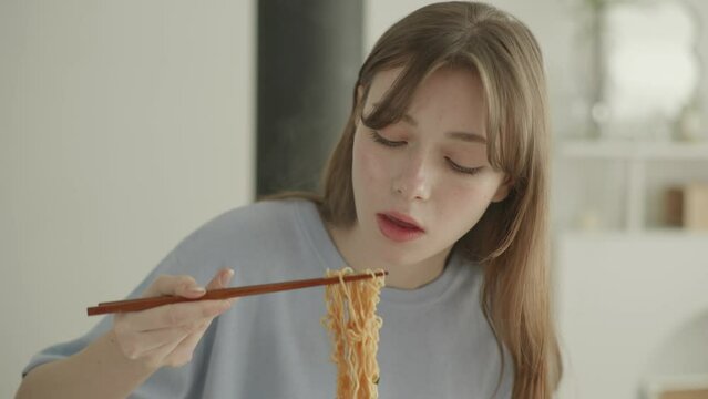 Young Woman Eating Hot Instant Ramen Noodles