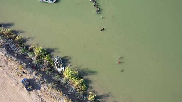 migrants crossing the Rio Grande into Eagle Pass, Texas. interaction between migrants and the Border Patrol, The video also showcases the presence of barbed wire along the border