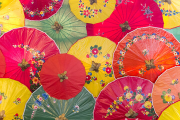 Many of beautiful and colorful umbrella with hand painting as wall decoration in tourism destination.