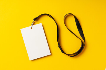 Blank nametag on a string on yellow background copy space - obrazy, fototapety, plakaty