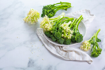 Fresh raw green bimi, broccolini and baby stick cauliflower in a bowl