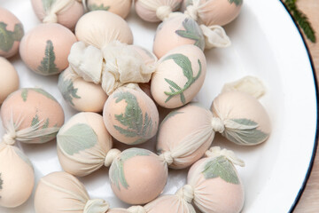A girl cooks eggs in tights with leaves. Easter
