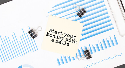 Yellow sticky notes with text START YOUR MONDAY WITH A SMILE on the white office desk. Business concept.