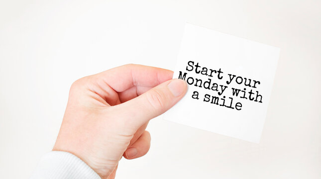 Businessman holding a card with text START YOUR MONDAY WITH A SMILE, business concept