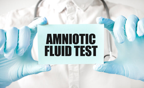 Doctor holding card in hands and pointing the word AMNIOTIC FLUID TEST