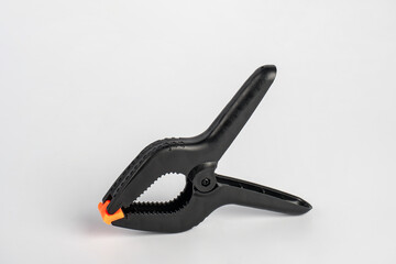 Obraz premium Black plastic spring clamp isolated on white background