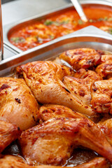 Metal tray with fresh baked chicken in a canteen