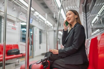 Young Asian Businesswoman Using Phone On The Public Skytrain