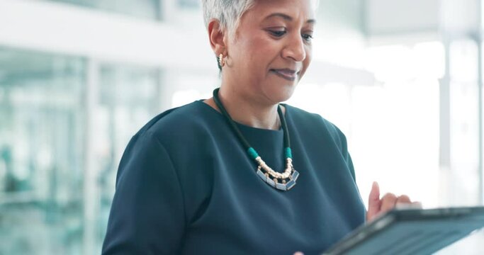 Walking, office and mature woman with tablet for online schedule, agenda or professional with report. Reading, scroll and senior manager in lobby with digital app in corporate networking business.