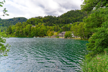 Scenic view of lakeshore with promenade at Lake Bled on a cloudy summer day. Photo taken August 8th, 2023, Bled, Slovenia.