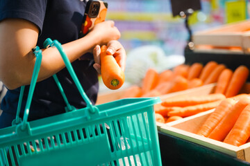 Woman holding grocery basket walk in supermarket. Attractive. female hold carrot pick up from shelf for health and wellness in shopping department. Choosing to buy carefully.