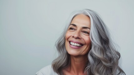 Fototapeta premium Portrait of mature woman with gray hair laughing and smiling. Gorgeous beautiful mature lady with fine wrinkles.