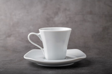 Empty white porcelain cup on gray stone background