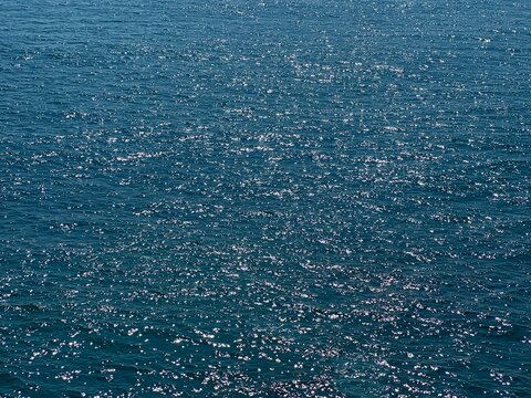Blue sea water shiny glittering background. 