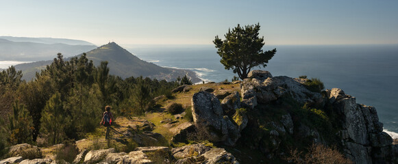 A hiker girl is enjoying panoramic views of Atlantic sea, in Galicia.