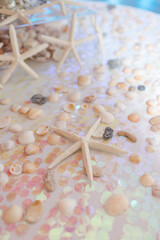 White starfish with iridescent confetti and seashells