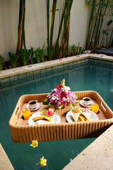 Fototapeta na wymiar Set of floating breakfast tray in swimming pool