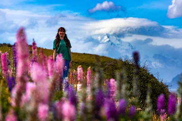Crédence de cuisine en verre imprimé Aoraki/Mount Cook hiker girl standing on the field of lupin flowers with mighty peak of mount cook in front of her  blooming colorful flowers near lake pukaki, canterbury, new zealand south island