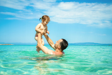 Fototapeta na wymiar happy father and child playing in the sea in nature