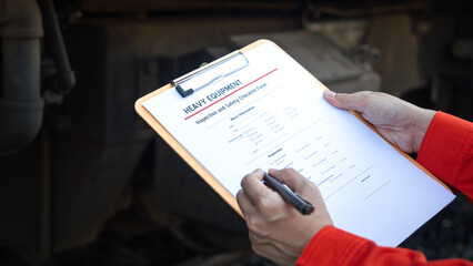 	
Action of a mechanic engineer is checking on heavy machine checklist form to verify the quality...