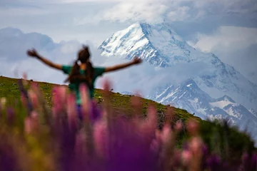 Papier Peint photo Aoraki/Mount Cook hiker girl standing on the field of lupin flowers with mighty peak of mount cook in front of her  blooming colorful flowers near lake pukaki, canterbury, new zealand south island