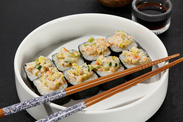 Assorted Sushi Rolls with Shrimp Tartare, Avocado, and Tobiko Caviar on a Modern Dark Surface
