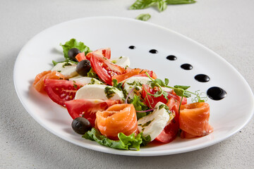 Salmon and mozzarella Caprese salad with fresh tomatoes, top view. Ideal for culinary magazines and healthy eating blogs