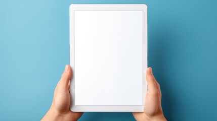 Hands holding digital tablet with blank screen on blue background,