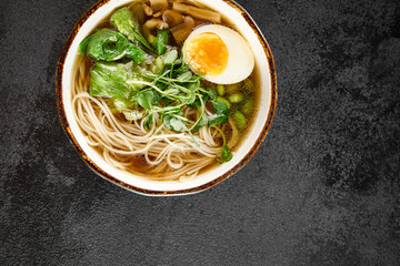 Aromatic ramen with a soft-boiled egg, leafy greens, and mushrooms, served in a rustic blue bowl