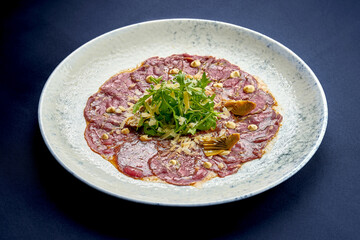 Italian carpaccio with artichokes, arugula in a plate. A delicious snack