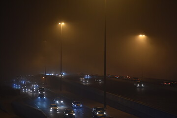 night traffic in the city .. Fog does not prevent life from going normally in the city crowded with...