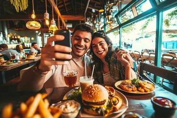 Keuken spatwand met foto Couple taking selfie with smart mobile phone at burger pub restaurant. Young people having lunch break at cafe bar venue. Life style concept with guy and girl hanging out on weekend, Generative AI © Pixel Nirvana