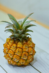 Pineapple on the white table. Little exotic pineapple.