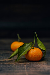 Still life of mandarin oranges with leaves. Fresh mandarin oranges fruit or tangerines on wooden table with leaves