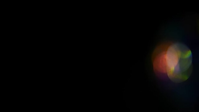 Iridescent highlights, rainbow glare on a black background to overlay and create a bright, sunny and interesting picture, abstract background