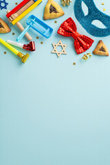 Purim holiday vertical arrangement: Top view triangular sweets, Jewish star symbols, and festive items like mask, confetti, and party blowers displayed on pastel blue setting, with a section for text