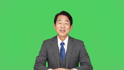 カメラ目線で話すミドル男性　アナウンサー　クロマキー合成用グリーンバック