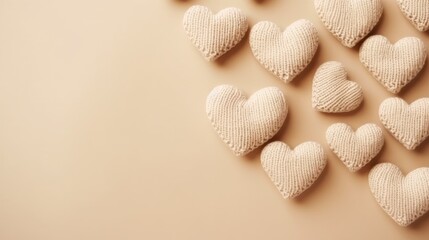 Fototapeta na wymiar Beige knitted hearts on a beige background, top view, with space for text. Valentine's Day, hobbies, knitting, love, health concept.