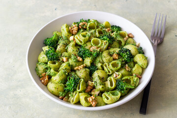 Pasta with broccoli, pesto sauce and nuts. Italian cuisine. Healthy eating.
