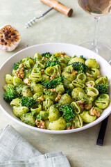 Pasta with broccoli, pesto sauce and nuts. Italian cuisine. Healthy eating.