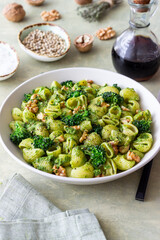 Pasta with broccoli, pesto sauce and nuts. Italian cuisine. Healthy eating.
