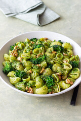 Pasta with broccoli, pesto sauce and nuts. Italian cuisine. Healthy eating.