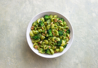 Pasta with broccoli, pesto sauce and nuts. Italian cuisine. Healthy eating.