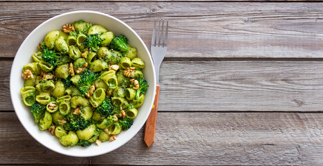 Pasta with broccoli, pesto sauce and nuts. Italian cuisine. Healthy eating.